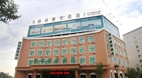 a building with a sign on top of it at GreenTree Inn Puyang Pushang Huanghe Road in Puyang