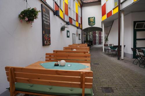 a row of wooden benches sitting next to a building at Hotel Der Greif in Leoben