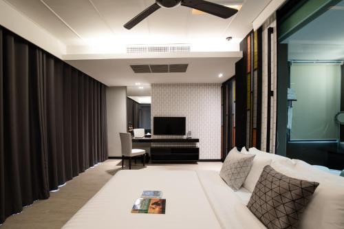 a living room with a couch and a desk at De Chai Oriental Nimman - SHA Plus in Chiang Mai