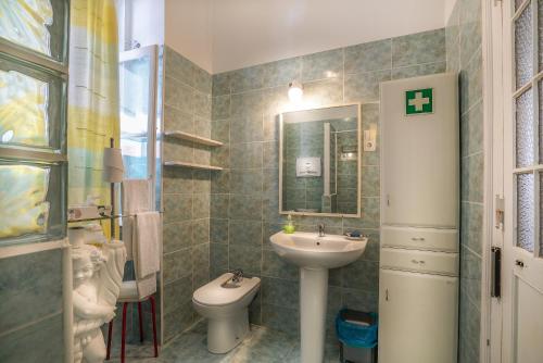bagno con lavandino, servizi igienici e specchio di Guest House VC17 a Sintra