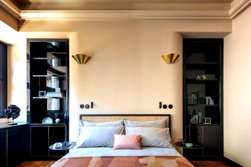 a bedroom with a bed with black shelves at HOMY Repubblica - A Luxury Collection in Milan