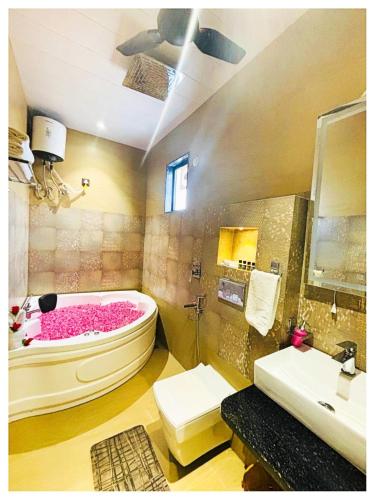 a bathroom with a pink tub and a sink at Hotel Moresta Restaurant and Bar Best Facility in Ajmer