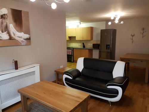 インバネスにあるLascala City Apartmentのリビングルーム(黒い革張りのソファ、テーブル付)