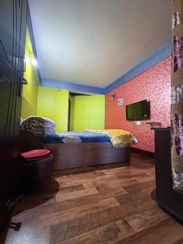 a room with two beds and a tv in it at Swarna Kamal Homestay in Darjeeling