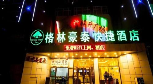 a building with a sign on the side of it at GreenTree Inn Xinjiang Uygur Autonomous Region Korla Bazhou Bus Terminal Beishan Road Express Hotel in Korla