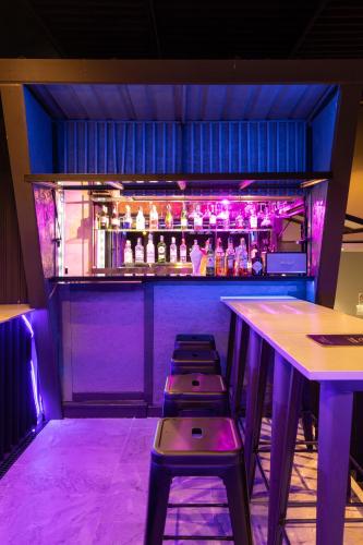 a bar with three stools in front of a bar at De Chai Oriental Nimman - SHA Plus in Chiang Mai