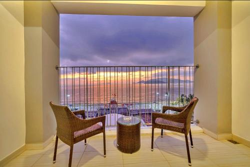 a room with a large window with chairs and a table at S79 Residence LYN Panorama in Nha Trang