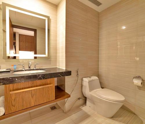 a bathroom with a toilet and a sink and a mirror at S79 Residence LYN Panorama in Nha Trang