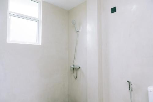 baño blanco con ducha y ventana en Anna Villa, en Tangalle