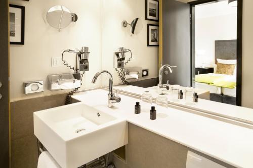 a bathroom with two sinks and a mirror at Hotel Hamburger Hof in Frankfurt/Main