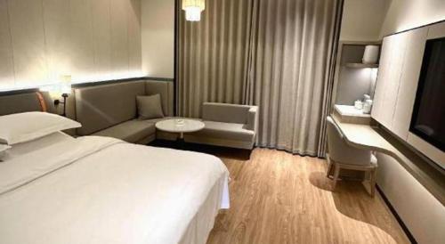 a hotel room with a bed and a chair and a table at Tianrun International Hotel in Dunhuang