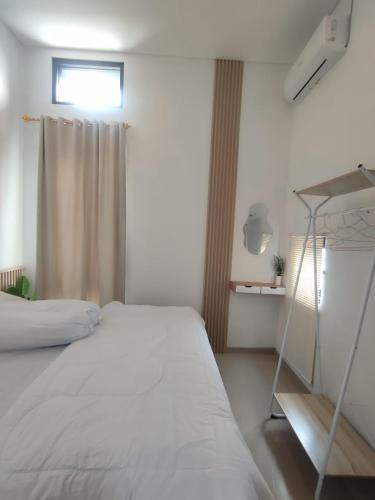 ein Schlafzimmer mit einem weißen Bett und einem Fenster in der Unterkunft Athara Villas Kav A5 Batu in Karangploso