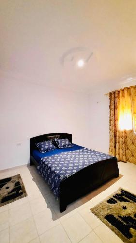 a bedroom with a bed with a blue comforter at Villa piscine midoun djerba in Triffa