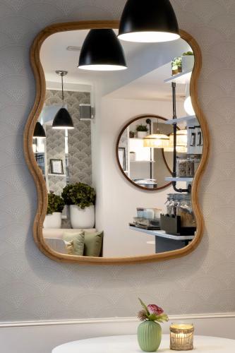 a bathroom with a mirror on a wall at Les 2 Villas in Trouville-sur-Mer
