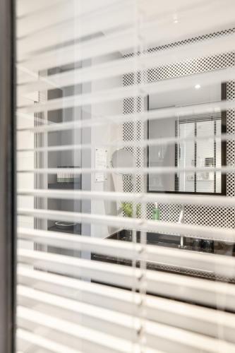 a view of a window with white blinds at Les 2 Villas in Trouville-sur-Mer