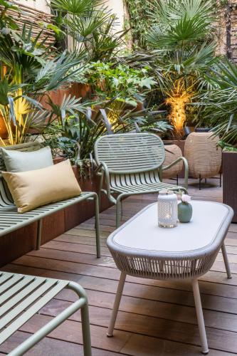a patio with chairs and a table and plants at Les 2 Villas in Trouville-sur-Mer