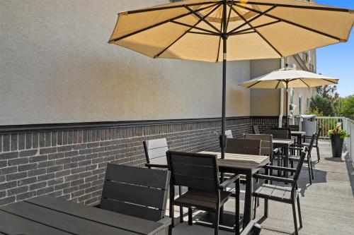 a row of tables and chairs with umbrellas at Ramada by Wyndham Drumheller Hotel & Suites in Drumheller