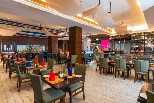 a dining room with tables and chairs and a restaurant at The K Hotel in Manama
