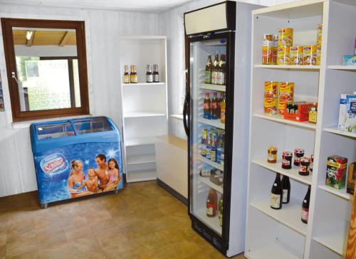 uma loja com um frigorífico com uma família em Campingplatz Aichelberg em Aichelberg