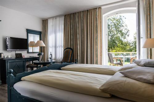 a bedroom with two beds and a desk and a window at Seehotel Frankenhorst - BW Signature Collection in Schwerin