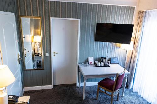 a hotel room with a table and a mirror at Seehotel Frankenhorst - BW Signature Collection in Schwerin