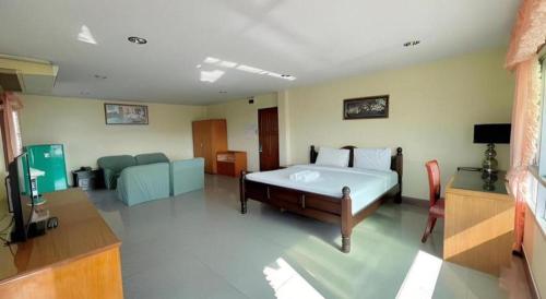 a bedroom with a bed and a couch and a television at Hihotel Saraburi in Sara Buri