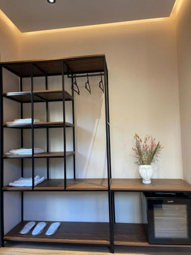 a black book shelf with a vase on it at Olivium Rooms in Vlorë