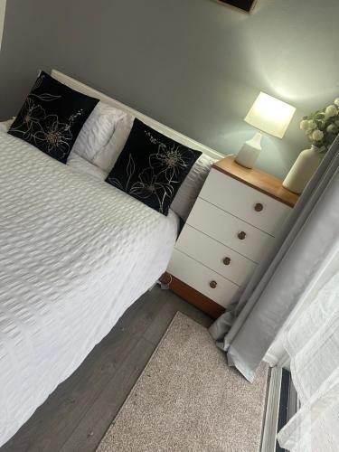 a bedroom with a bed and a night stand with a lamp at Comfortable Stay With Garden View Near Long Riding in Basildon
