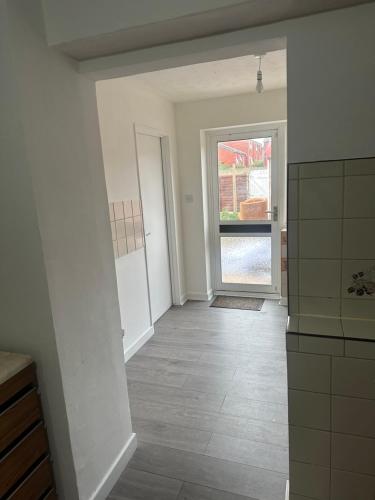 an empty room with a hallway with a door and a window at Comfortable Stay With Garden View Near Long Riding in Basildon