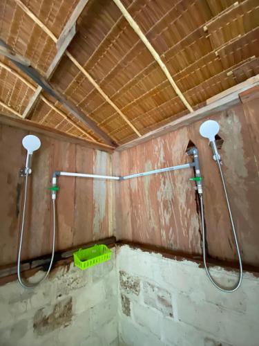 a bathroom with two shower heads on the wall at Famwall Homestay Raja Ampat in Keruo