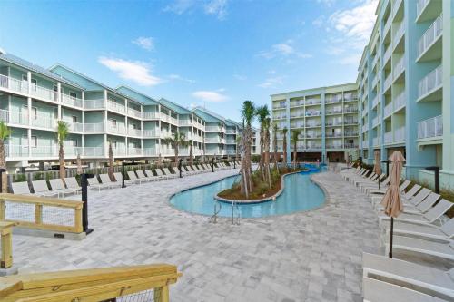 a resort courtyard with a pool and palm trees at Hilton Garden Inn Orange Beach in Orange Beach