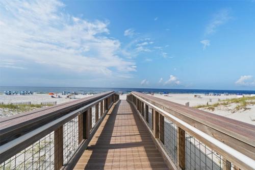 a boardwalk to the beach with people on the beach at Hilton Garden Inn Orange Beach in Orange Beach