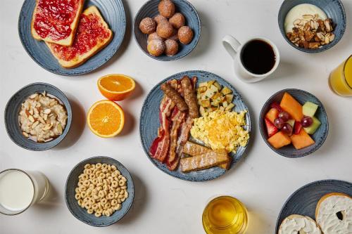 a table with plates of breakfast foods and coffee at Hyatt House Morristown in Morristown