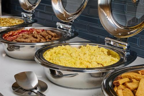 a buffet of different types of food in pans at Hyatt House Morristown in Morristown