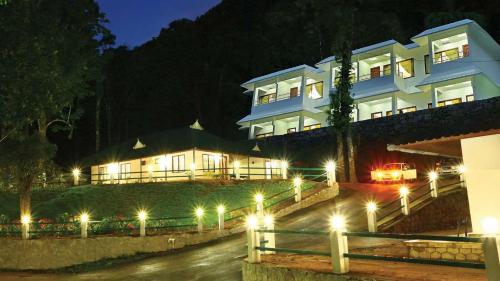 a large building with lights in front of it at night at Seven Springs Plantation Resort in Munnar
