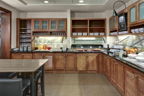 a large kitchen with wooden cabinets and a table at Hyatt Place Detroit/Auburn Hills in Auburn Hills