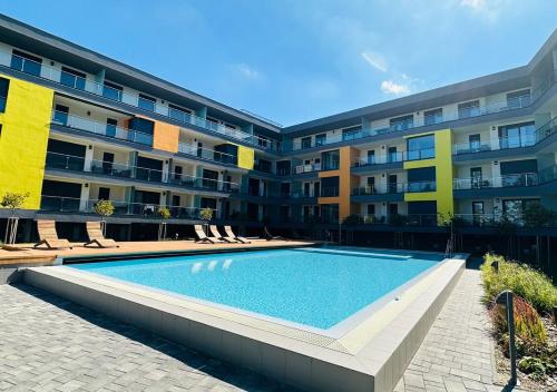einem Pool vor einem Apartmentgebäude in der Unterkunft Casa Romana 2 Siófok apartman in Siófok