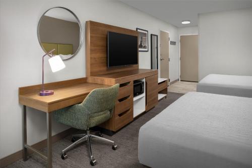 a hotel room with a desk and a mirror at Hampton Inn Butte in Butte