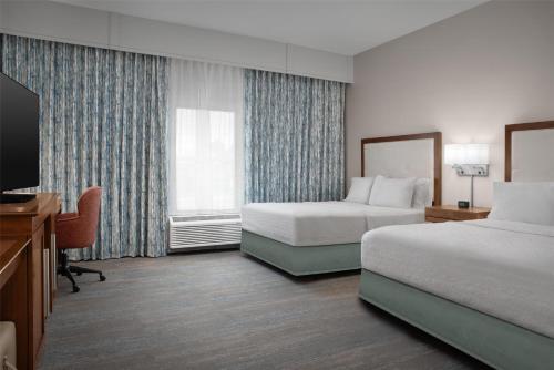 a hotel room with two beds and a television at Hampton Inn and Suites by Hilton Vero Beach-Downtown in Vero Beach