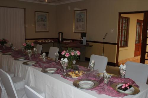 a long table with plates and bowls of food on it at Prinshof Manor Guesthouse in Pretoria