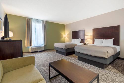 a hotel room with two beds and a couch at Quality Inn & Suites NJ State Capital Area in Morrisville