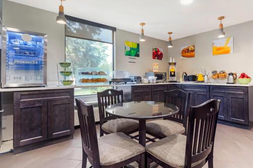 a kitchen with a table and chairs and a counter at Quality Inn & Suites NJ State Capital Area in Morrisville