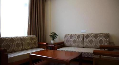 a living room with a couch and a table at GreenTree Inn Anhui Bozhou West Guangming Road Tangwang Avenue Shall Hotel in Bozhou