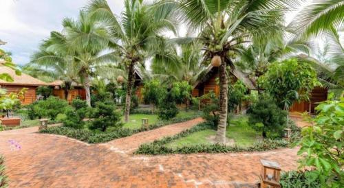 a resort with palm trees in front of a building at HON BA LAGI BEACH RESORT in La Gi