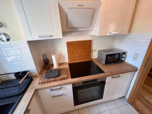 a kitchen with white cabinets and a microwave at Casper-David-Friedrich 2 in Bad Schandau