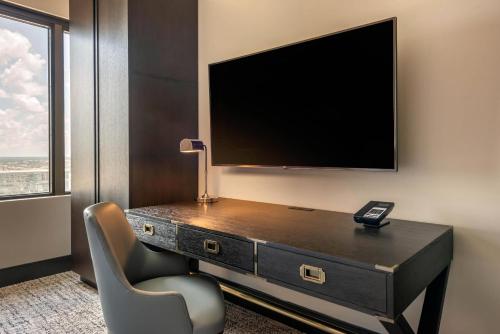 a room with a desk with a tv and a chair at Cambria Hotel Houston Downtown Convention Center in Houston