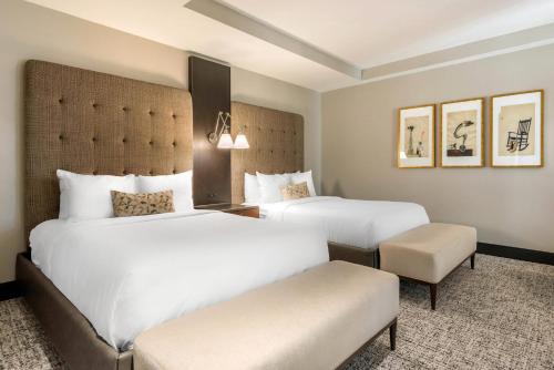 a hotel room with two beds and a chair at Cambria Hotel Houston Downtown Convention Center in Houston