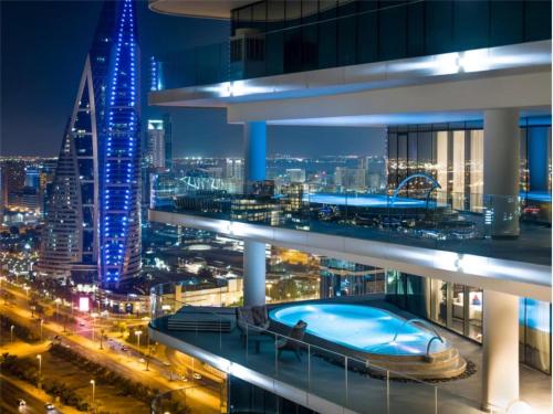 a view of a city at night with a swimming pool at Conrad Bahrain Financial Harbour in Manama