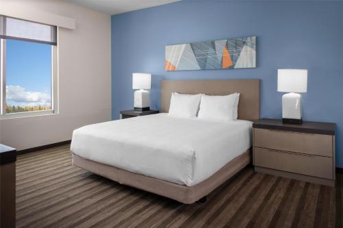 a bedroom with a large white bed and a window at Hyatt House The Woodlands-Shenandoah in Shenandoah