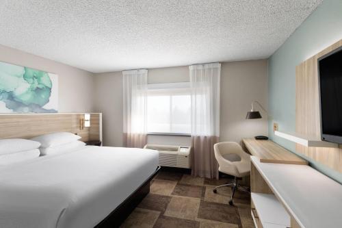 a hotel room with a bed and a desk with a computer at Wyndham Garden Newark Fremont Silicon Valley in Newark